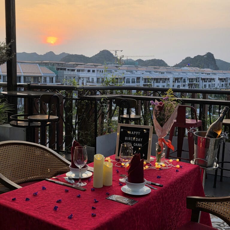 Birthday dinner table set at sunset on the Roza terrace, Cat Ba Town