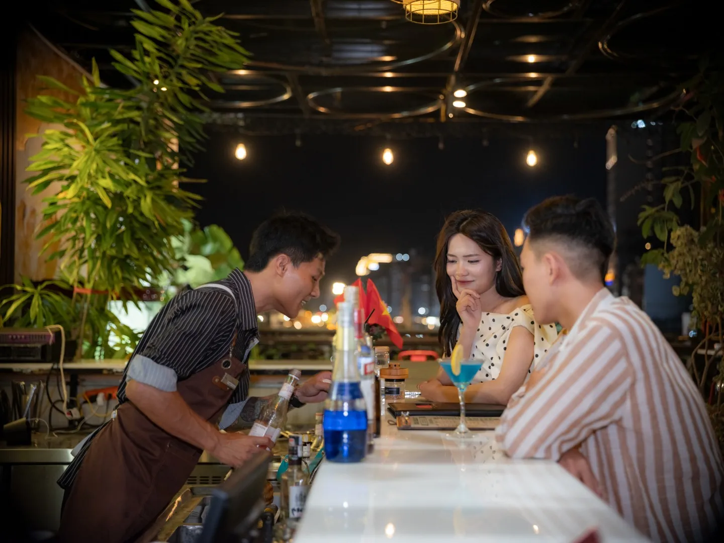 Bartender serving cocktails at Roza Bar rooftop in Cat Ba